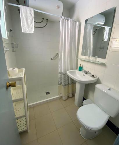a bathroom with a toilet and a sink and a shower at Hostal Avenida by Bossh! Hotels in Chipiona