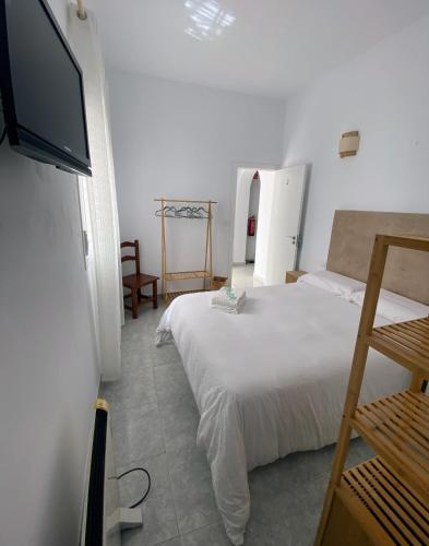 a bedroom with a bed and a flat screen tv at Hostal Avenida by Bossh! Hotels in Chipiona