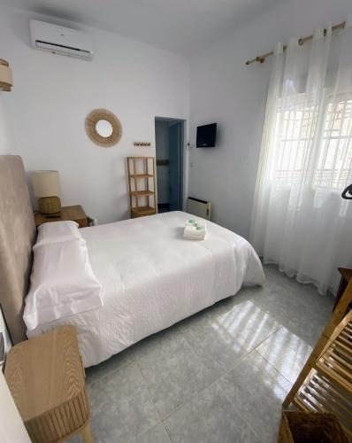 a bedroom with a large white bed with white sheets at Hostal Avenida by Bossh! Hotels in Chipiona