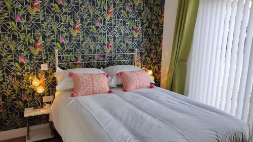 a bedroom with a bed with a patterned wall at double room in Wadebridge