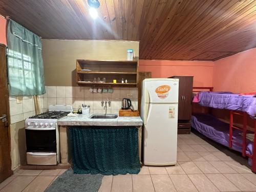 a kitchen with a sink and a refrigerator in a room at Alojamiento El Remanso in Puerto Iguazú