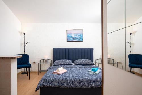 ein Schlafzimmer mit einem Bett und zwei blauen Stühlen in der Unterkunft APARTMENT MAJER 2 in Medulin