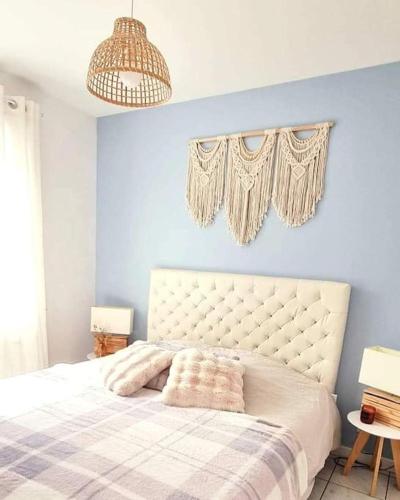 Saint-Aignan-Grand-Lieu的住宿－Appartement proche de l'aéroport de Nantes，一间卧室设有一张蓝色墙壁的大床