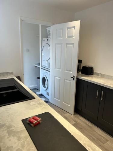 a kitchen with a white door and a washing machine at Ferrers House in Doncaster