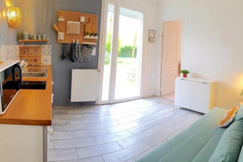 uma cozinha e sala de estar com um sofá e uma mesa em Appartement proche de l'aéroport de Nantes em Saint-Aignan-Grand-Lieu