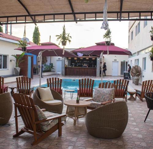um pátio com cadeiras e mesas e uma piscina em Locanda group B&B em Luanda