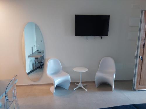 a room with two chairs and a table and a mirror at Hotel Belvedere Resort in Castellammare del Golfo