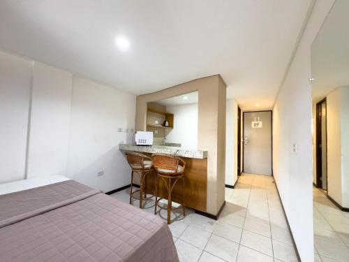 a hotel room with a bed and a kitchen at Pipas Bay in Pipa