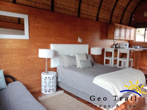 a bedroom with a bed and a couch and a kitchen at Geo Trail Lodge and Spa in Barberton
