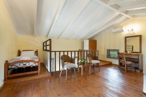 a bedroom with a bed and a table and a desk at Villa Adriana in Arménoi