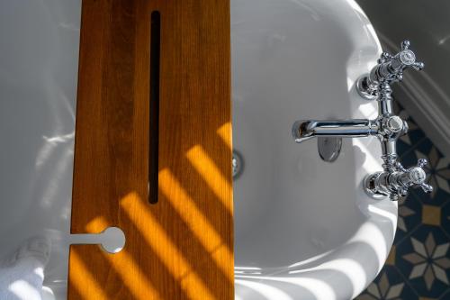 a bathroom with a white sink and a wooden door at Coast Guest House in Whitby