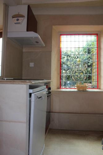 Il comprend une cuisine avec une fenêtre et un réfrigérateur blanc. dans l'établissement La Creullinnerie Bis, à Morville
