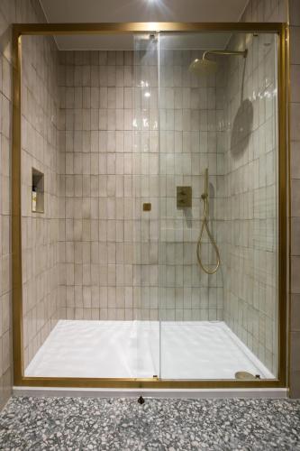 a shower with a glass door in a bathroom at Worplesdon Place Hotel in Guildford