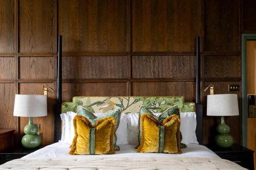 a bedroom with a bed with two lamps and two pillows at Worplesdon Place Hotel in Guildford