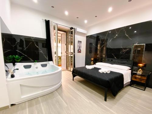 a large bathroom with a tub and a bed at Aliva suite LT in Palermo