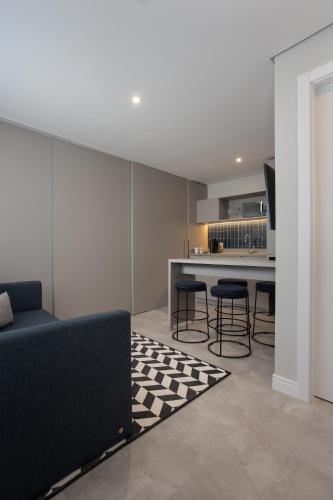 a living room with a couch and a kitchen at Brava Mundo Hotel Boutique OFICIAL in Itajaí