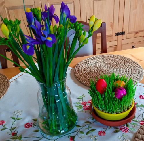 a vase with flowers and easter eggs on a table at Pension Fanlor in Zubčická Lhotka