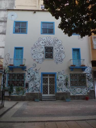 a white building with blue windows and a door at Solar Hostel Beach Copacabana in Rio de Janeiro