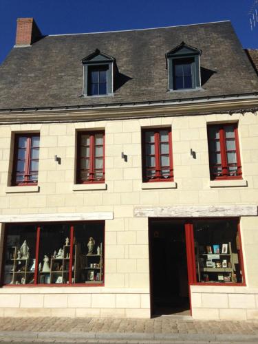 a white brick building with red shuttered windows at A MARIE ET GABRIEL in L'Ile-Bouchard