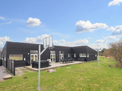 un edificio negro con un aro de baloncesto delante de él en 16 person holiday home in V ggerl se en Bøtø By