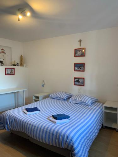 a bedroom with a bed with two blue towels on it at A MARIE ET GABRIEL in L'Ile-Bouchard