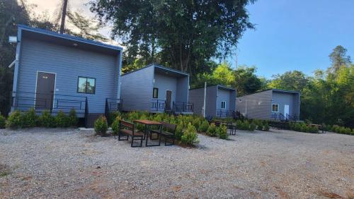 una fila de casas móviles con mesa y bancos en Riverhilk khaoyai en Ban Bung Toei