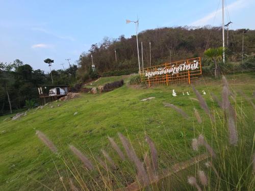 a field with a sign on the side of a hill at Riverhill khaoyai บ้านกล่อง in Ban Bung Toei