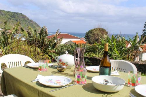 a table with a bottle of wine and plates on it at Casa dos Magalhães in Vila do Porto