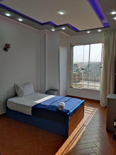 ein Schlafzimmer mit einem Bett und einem großen Fenster in der Unterkunft dream pyramids view in Kairo