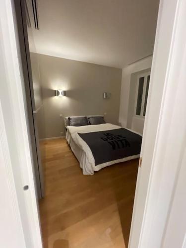 - une chambre avec un lit et une couette noire dans l'établissement 5 mn du centre de Beaulieu., à Beaulieu-sur-Mer