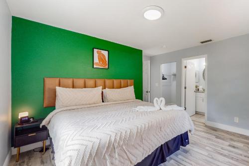 a bedroom with a green wall and a large bed at BayCation in Tampa