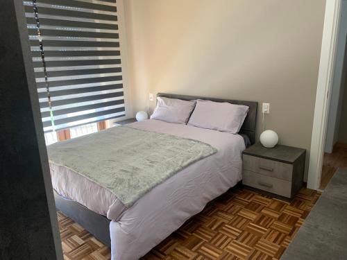 a bedroom with a large bed with a nightstand and a window at OASI ZEN VARESE - Tra laghi e monti - in Varese