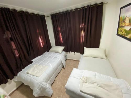 a living room with two beds and a window at Villa arri atlas in Bine el Ouidane