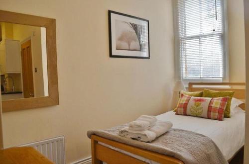 a bedroom with a bed with a mirror and towels on it at Noa Residence in Oxford