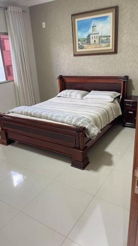 a bed in a bedroom with a picture on the wall at Casa próximo do aeroporto de Brasília in Brasilia