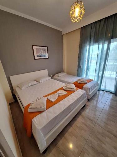 a bedroom with two beds and a chandelier at KALLIÁNI HOUSE vila kiki in Flogita