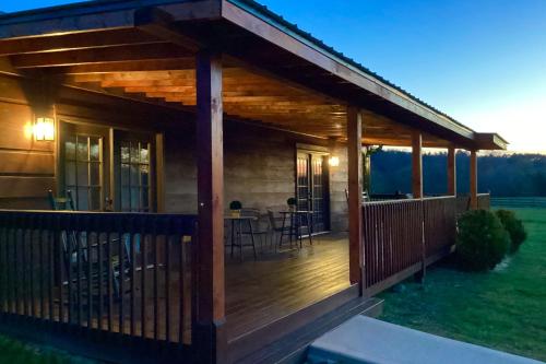 a wooden cabin with a deck with a bar at Lil Yellowstone in Morganton
