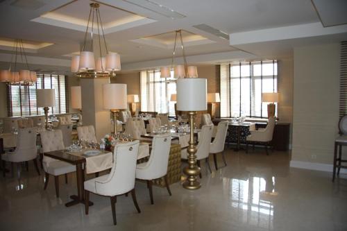 une salle à manger avec une table et des chaises blanches dans l'établissement Volga Premium Hotel, à Tcheboksary