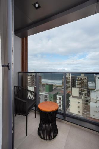 a balcony with a table and a view of the city at Brava Mundo Hotel Boutique OFICIAL in Itajaí