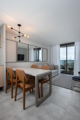 a kitchen and dining room with a table and chairs at Brava Mundo Hotel Boutique OFICIAL in Itajaí