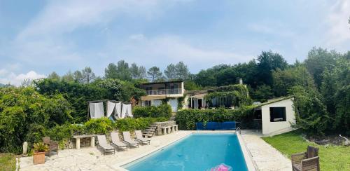 une maison avec une piscine devant une maison dans l'établissement 5 Bedroom Villa with magnificent views, à Le Bar-sur-Loup