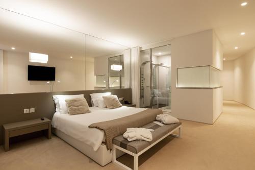 a bedroom with a large bed and a television at Tempus Hotel & Spa in Ponte da Barca