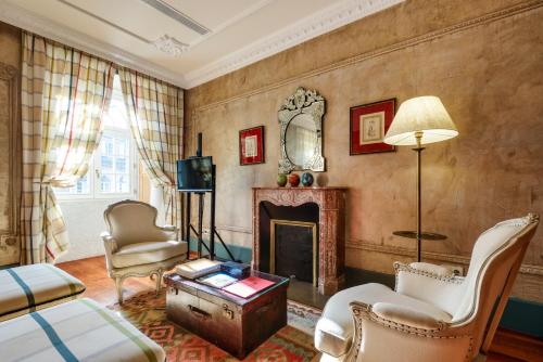 a living room with a fireplace and chairs at M Maison Particulière Porto in Porto