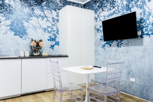 a dining room with a white table and chairs at La Bella Vita - In Blu in Sottomarina