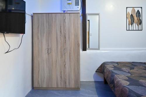 una camera da letto con armadio in legno accanto a un letto di Ô Calme Guesthouse a San Vicente
