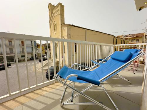 un par de sillas azules sentadas en un balcón en Portosalvo Holiday House, en Marina di Ragusa
