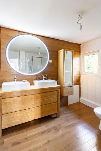une salle de bain avec deux lavabos et un grand miroir dans l'établissement Maison de charme près de Saint-Germain-en-Laye, barbecue inclus, à Le Pecq