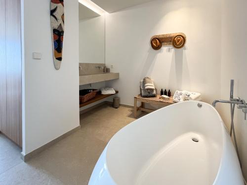 La salle de bains est pourvue d'une grande baignoire blanche. dans l'établissement Villa d'Exception avec piscine à Bandol - Villa Kiara, à Bandol
