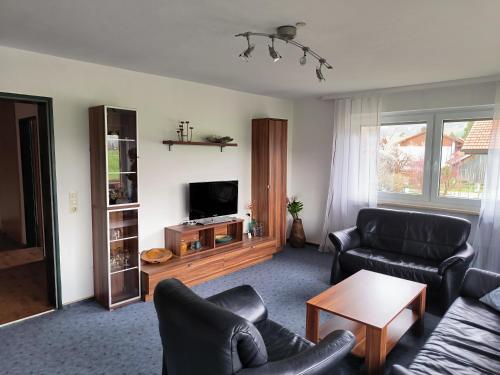 uma sala de estar com dois sofás e uma televisão em Haus Christine em Halblech