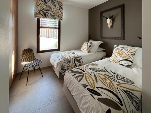 - une chambre avec 2 lits et une chaise dans l'établissement Villa d'Exception avec piscine à Bandol - Villa Kiara, à Bandol
